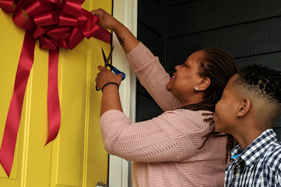 Angel cuts the ribbon to her new home